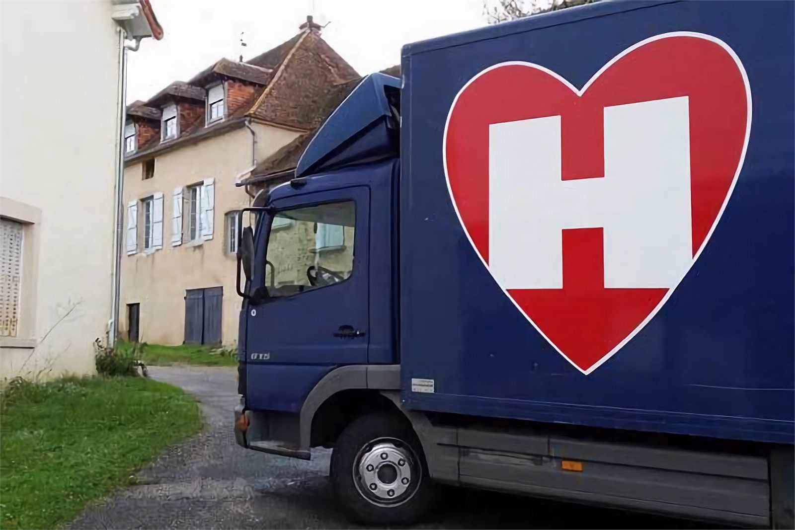 Donkerblauwe verhuiswagen van Harteveld met het rode hart en de witte H